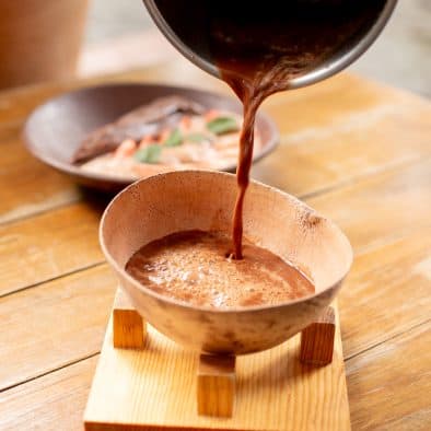 Authentic Mexican hot chocolate served in traditional wooden bowl.