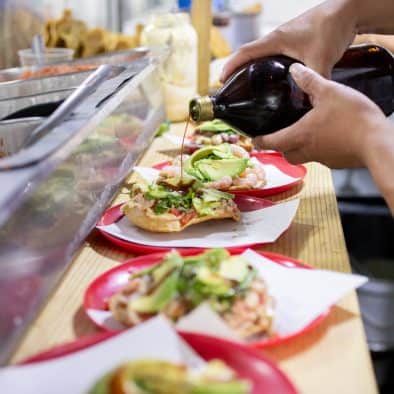 Preparing delicious tacos on a food tour in Juarez, showcasing local flavors.