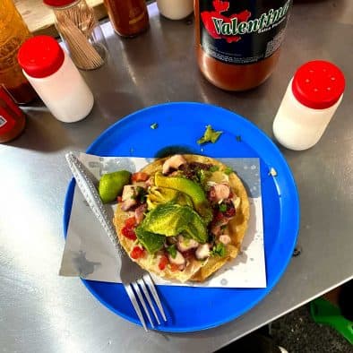 Delicious street food topped with fresh avocado and octopus, perfect for wine pairing.