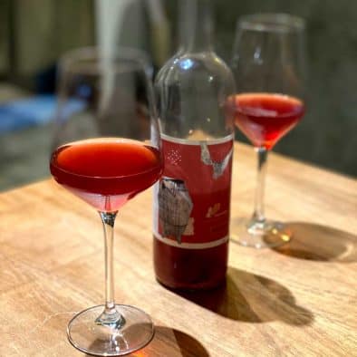 Glasses of red wine with street food in the background, perfect for wine and street food tasting.
