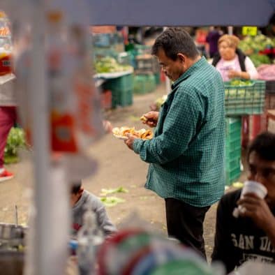 Bustling market scene at Central de Abastos with local vendors and fresh produce.